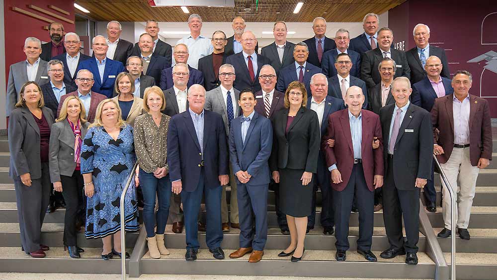 TAMU Engineering Advisory Council group standing on stairs inside the Zachry Engineering Education Complex.