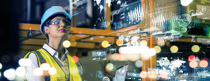 Woman in lab wearing construction outfit with graphics of a map, charts and graphs