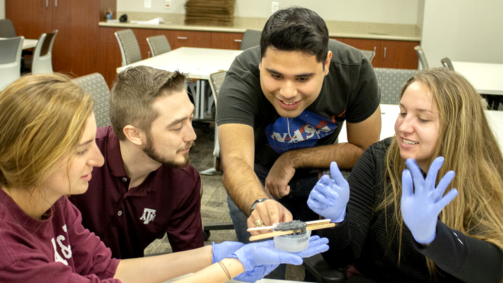 Four students hold a 3D printed mold of an infant's ear.