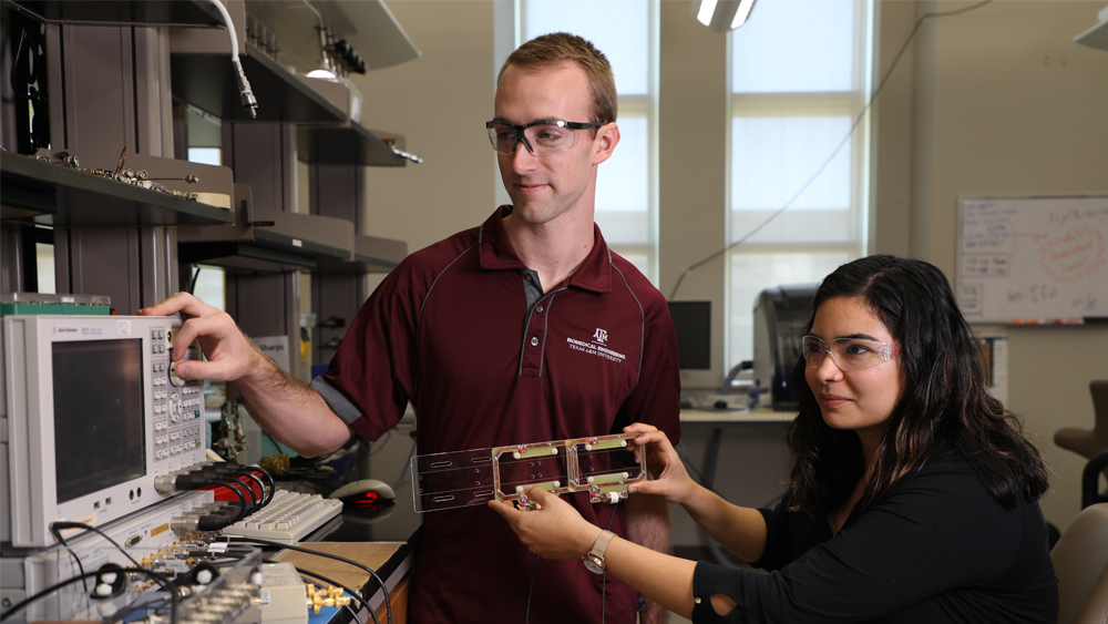 两名学生在实验室操作监控设备