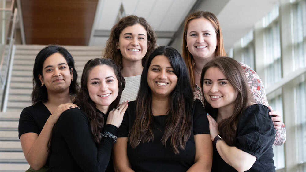 Raghavan博士站在楼梯的Emerging Technology Building with her lab students.