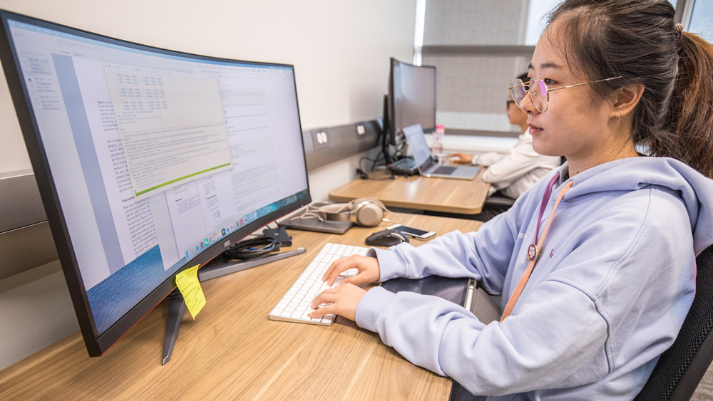 在实验室研究计算机的女学生。