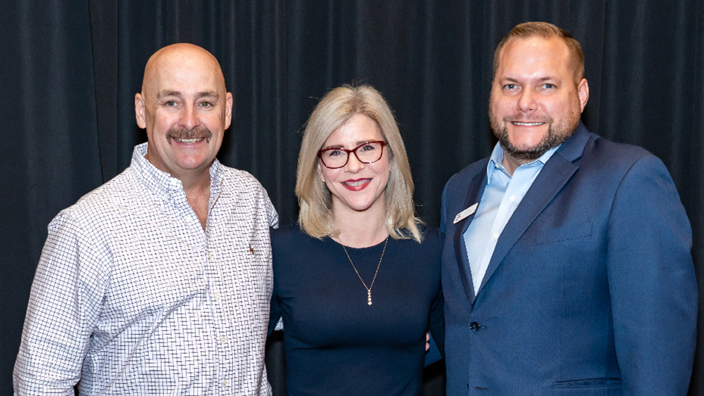 迪伊、道恩·埃利斯和另一个男人站在一起，面带微笑