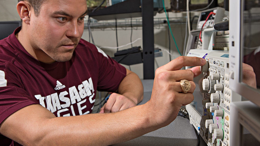 一名男生正在转动设备的旋钮。