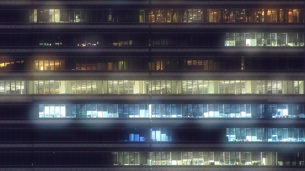 Office building with some floor lights on, some floor lights off.