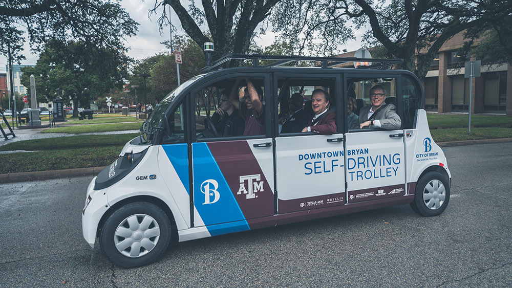 Dr. Sri Saripalli with Texas A&M System Chancellor John Sharp, Bryan Mayor Andrew Nelson and others riding in an autonomous vehicle in Downtown Bryan.