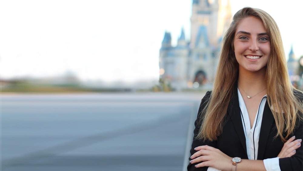 Stephanie Cruz stands in front of the Cinderella Castle at Walt Disney World resort.