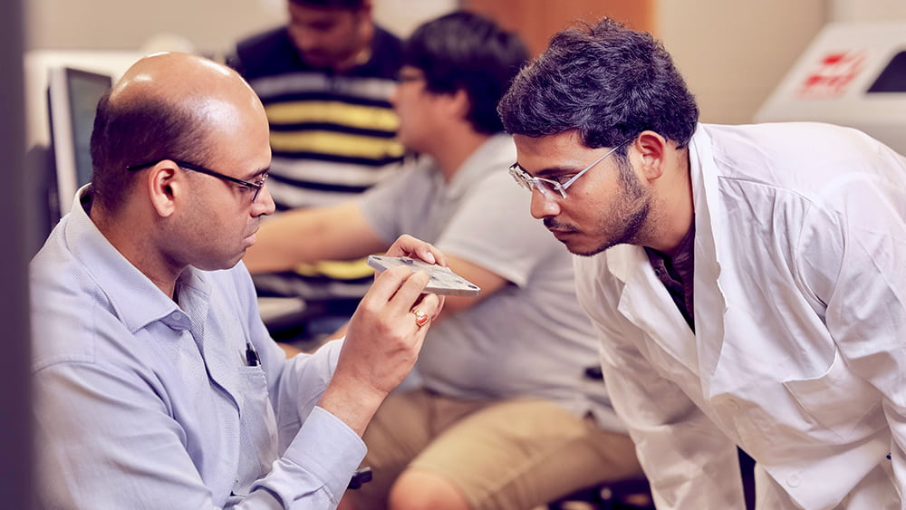 Dr. Satish Bukkapatnam shows a material to a student.
