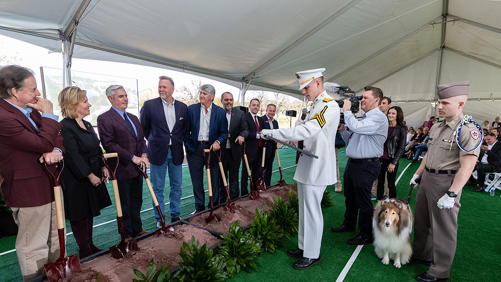 蒂姆·利奇提出了与他的家人,罗斯志愿者and Reveille as he accepts his award plaque.