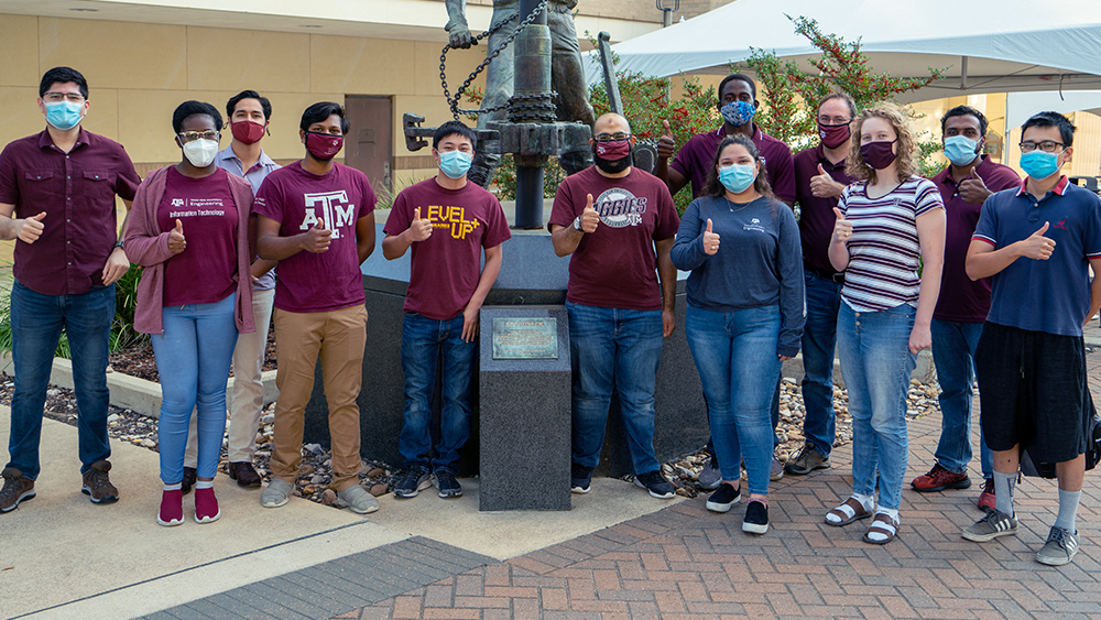 Mentor和Aggie 2020 NASA团队的几名成员戴着口罩，竖起了大拇指