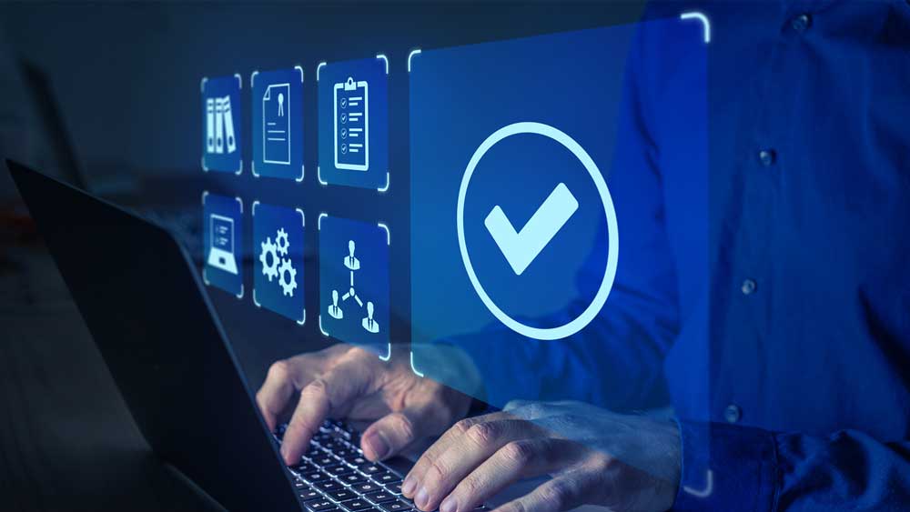 A man in business casual attire works on a laptop. Several floating virtual icons representing regulations and standardization hover above his hands on the keyboard.