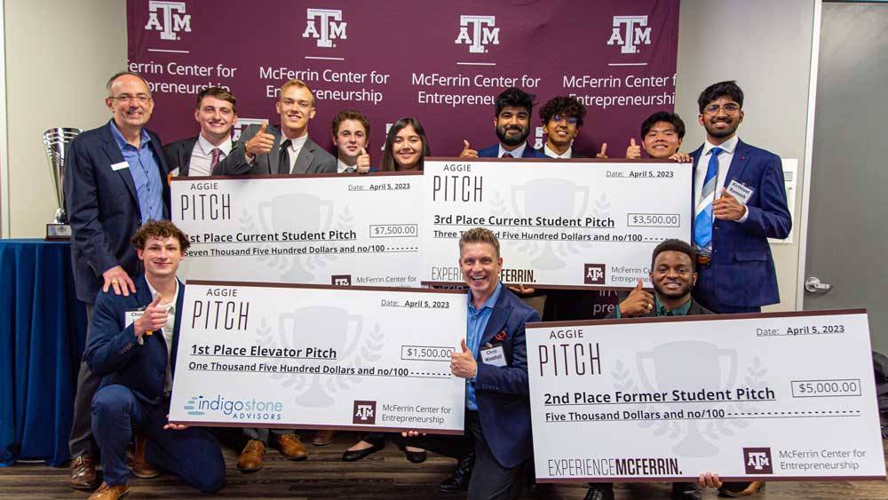 Chris Curran and his students with their large checks at the Mcferrin Center for Entrepreneurship Aggie PITCH contest.