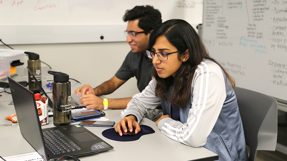 一位女学生在她的笔记本电脑上工作。